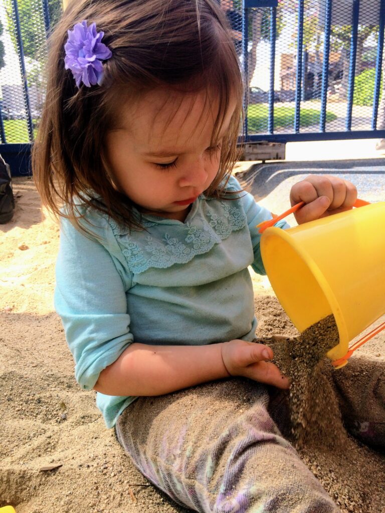 Young child exploring textured materials during early intervention therapy.